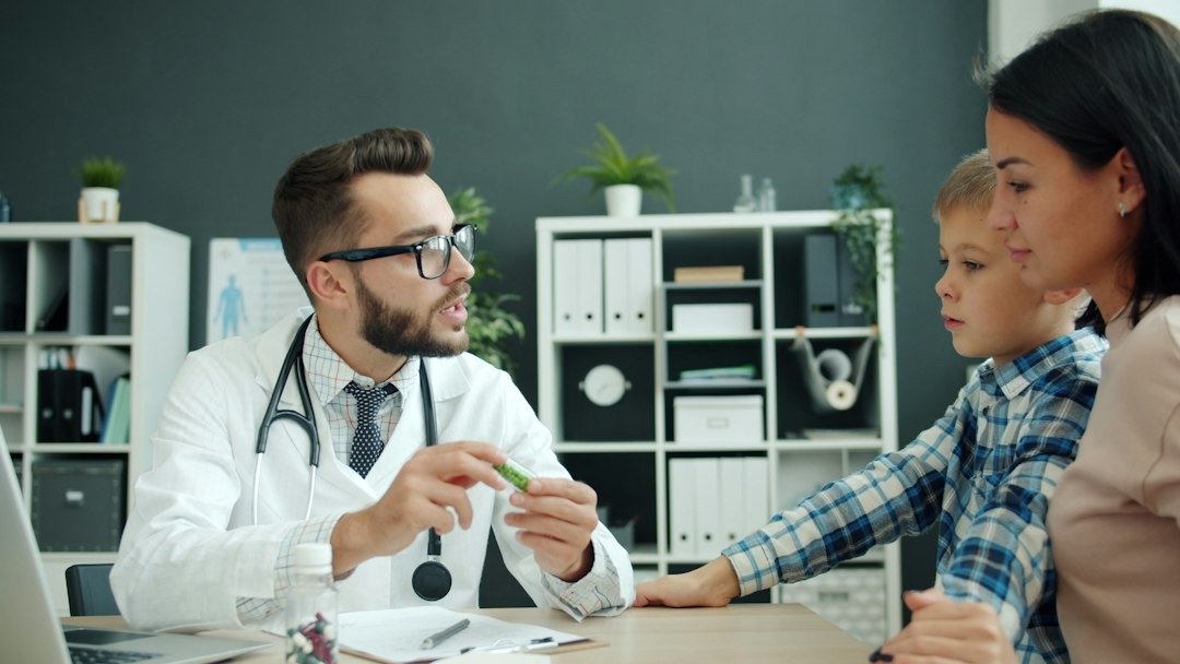 Smiling doctor with glasses and stethoscope around his neck.
